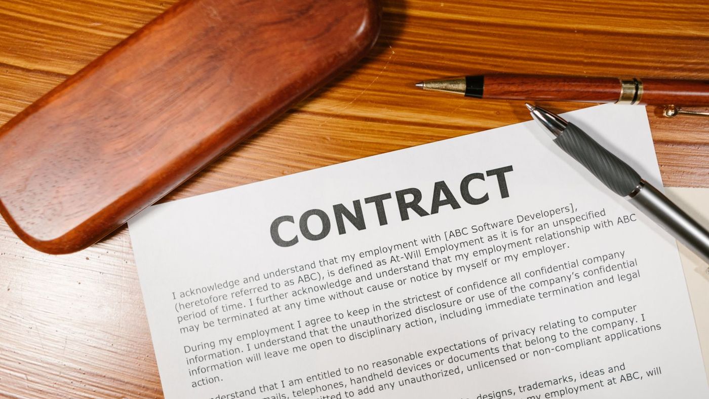 Contract document with a pen resting on a wooden desk