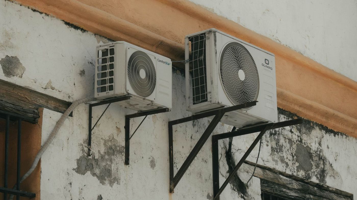 Air conditioner compressor units mounted on an exterior building wall
