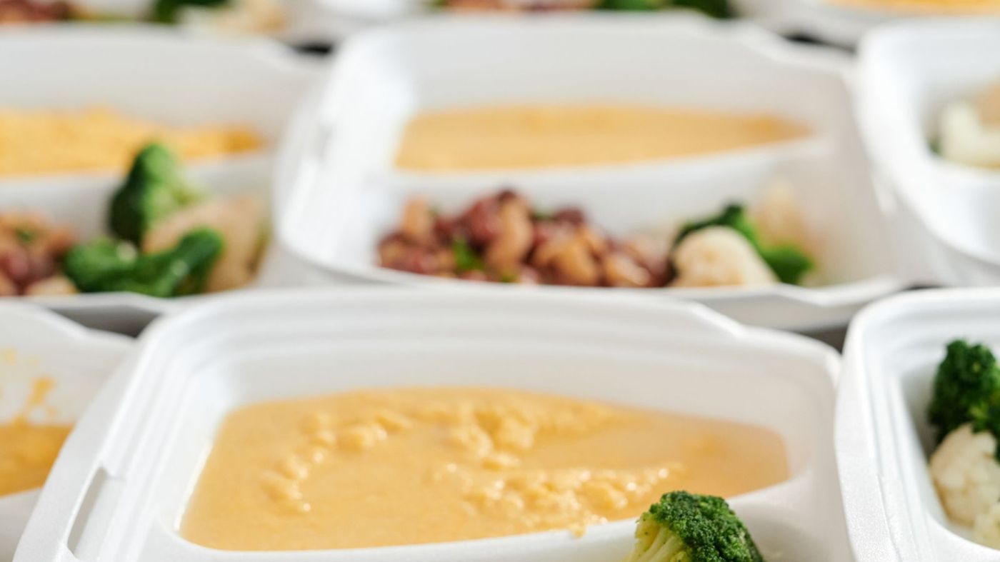 Meal containers filled with soup and vegetables ready for delivery