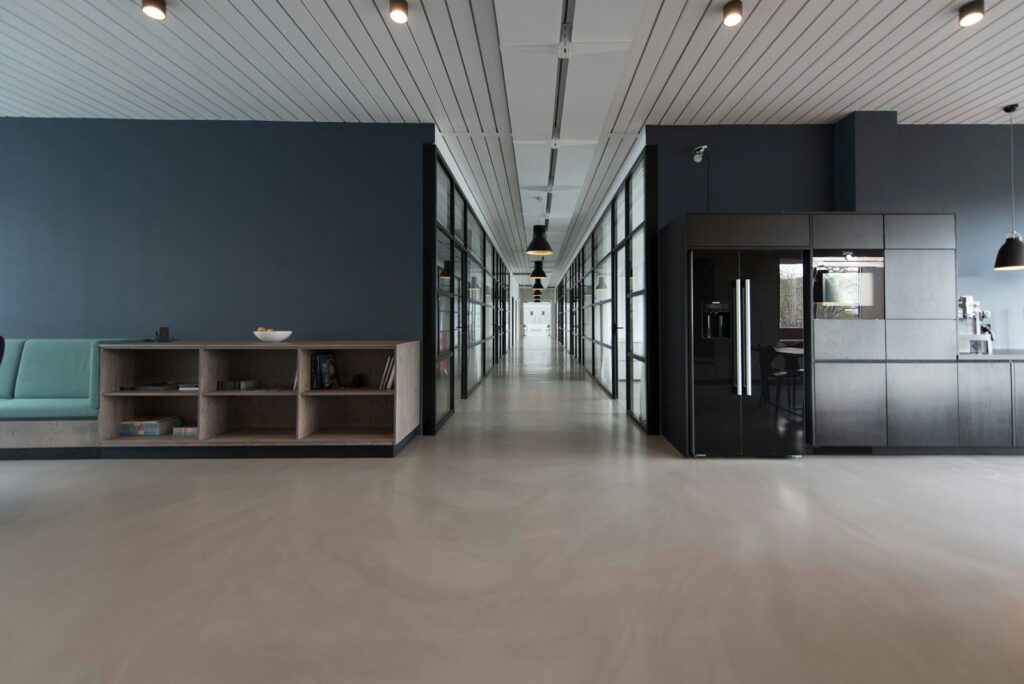 Empty modern office hallway with glass-walled rooms