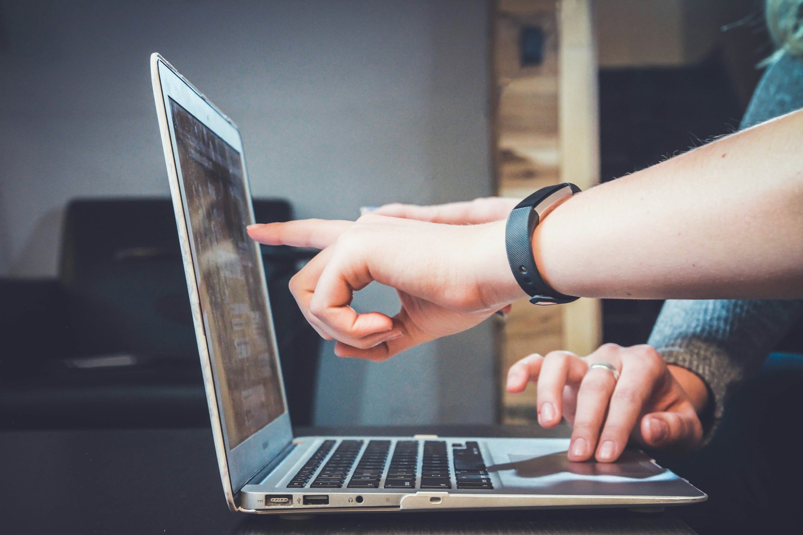 Person using a laptop and phone while managing online reviews