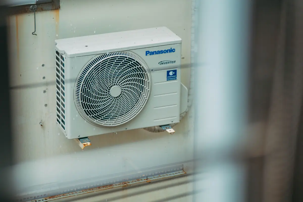 Wall-mounted outdoor air conditioning unit seen through a window