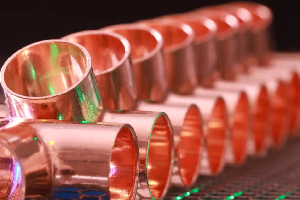 Row of shiny copper plumbing pipe fittings