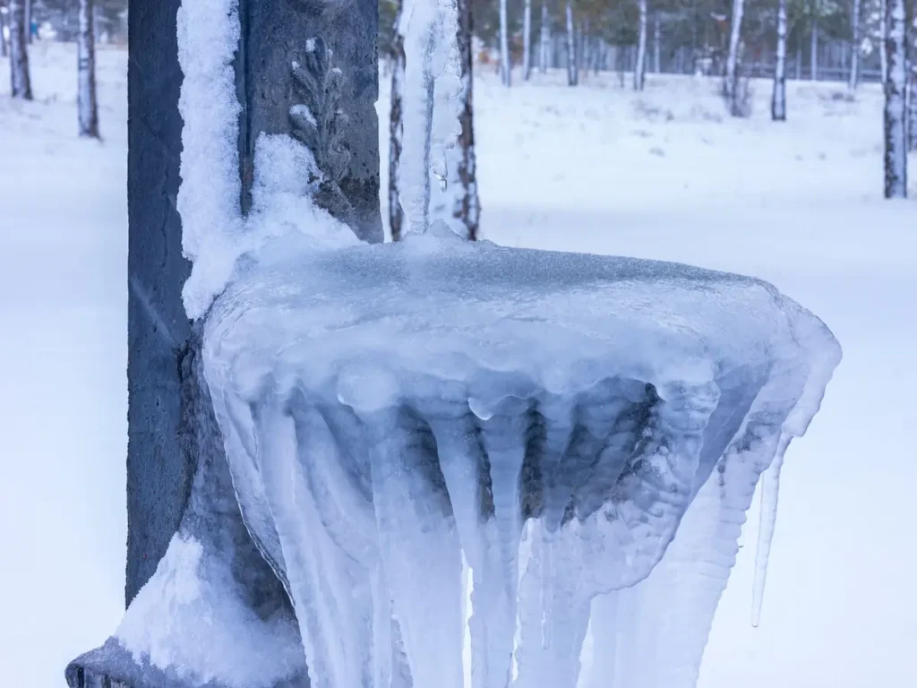 Outdoor water tap and basin encased in ice after a hard freeze