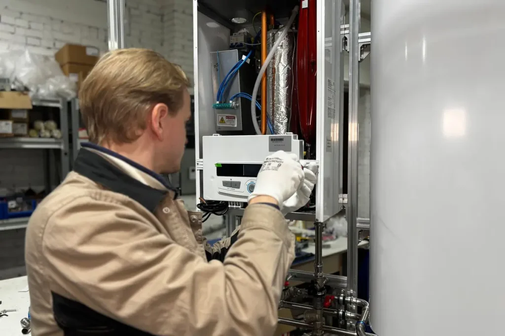 HVAC technician servicing the controls of a residential heating system