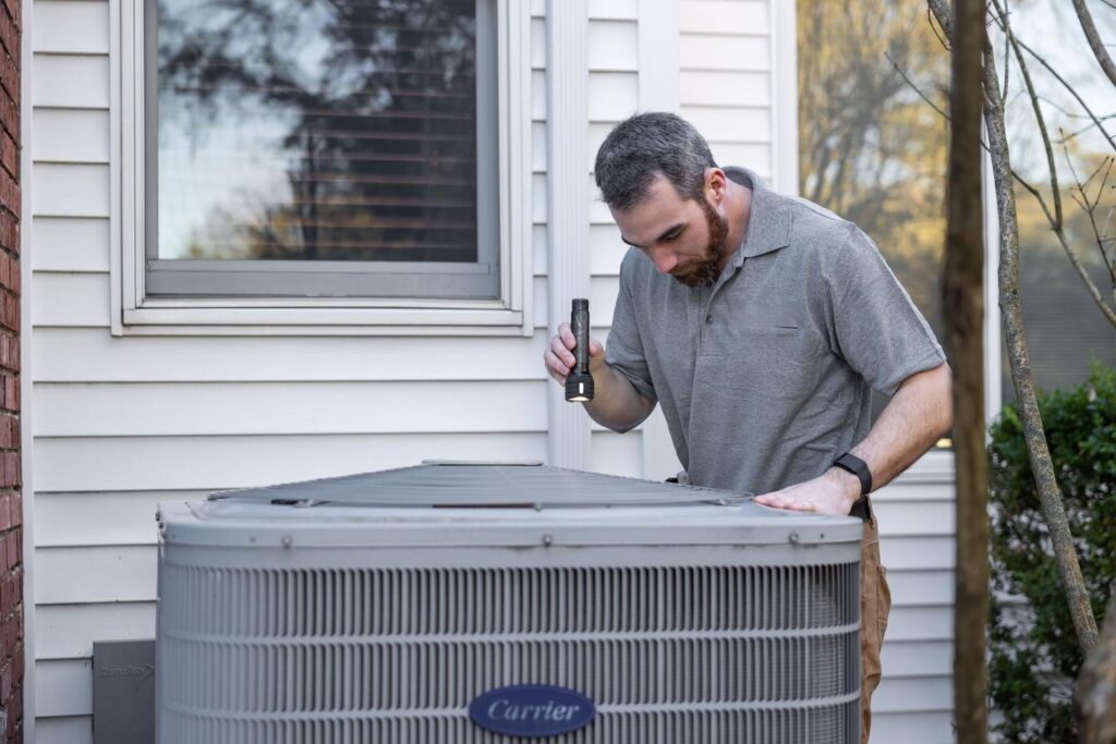 HVAC technician servicing an outdoor condenser unit