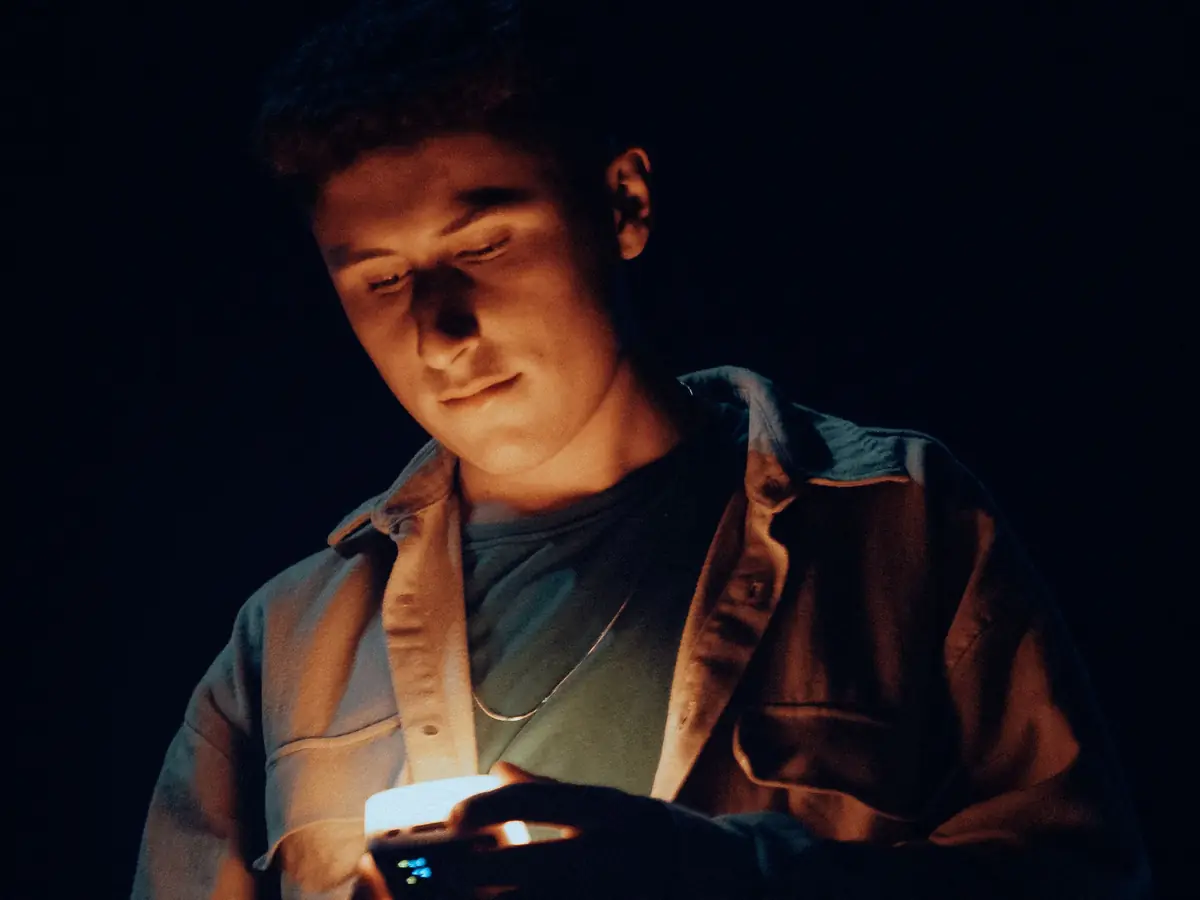 Man looking at his phone in the dark late at night
