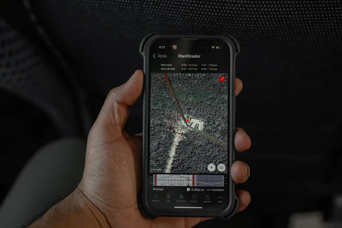 Hand holding a smartphone showing a map with a location pin