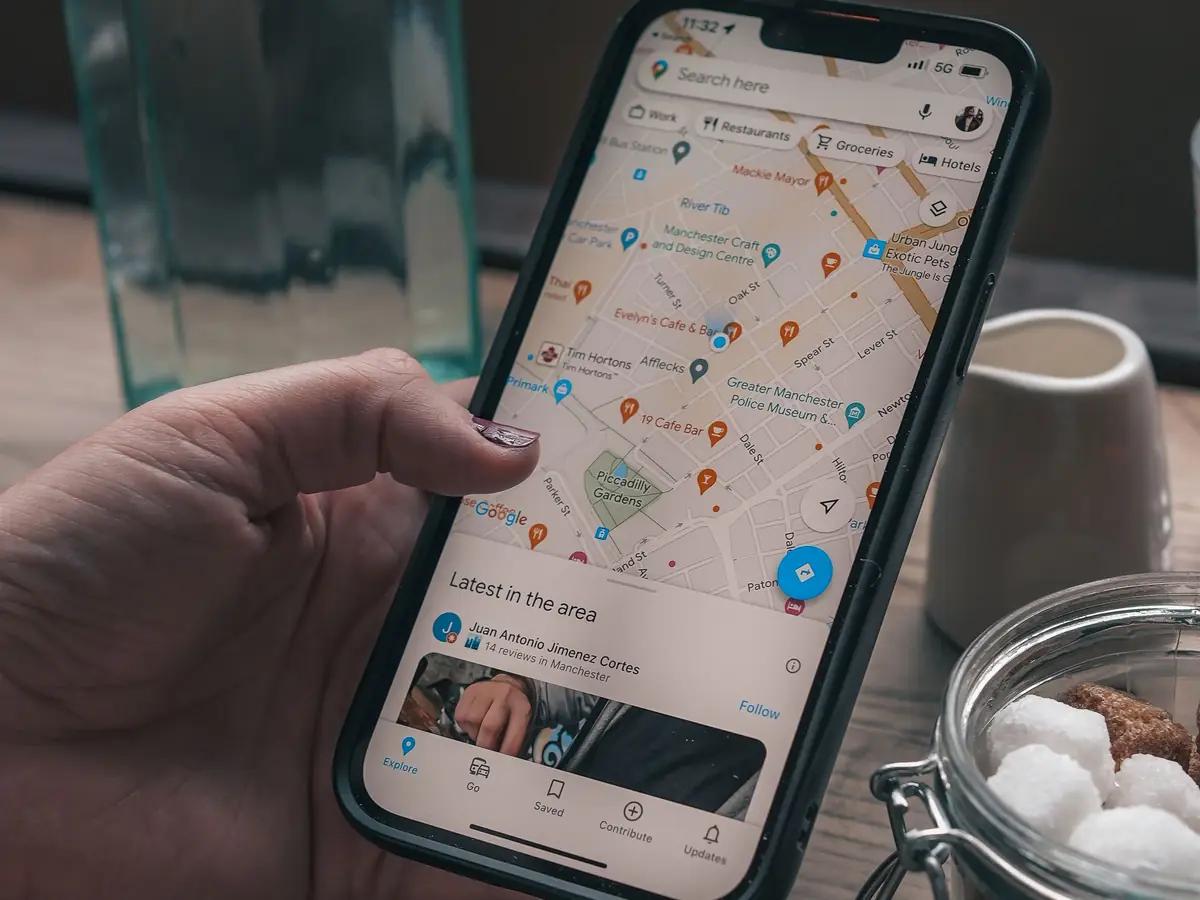 Person searching a map app on a smartphone for nearby businesses