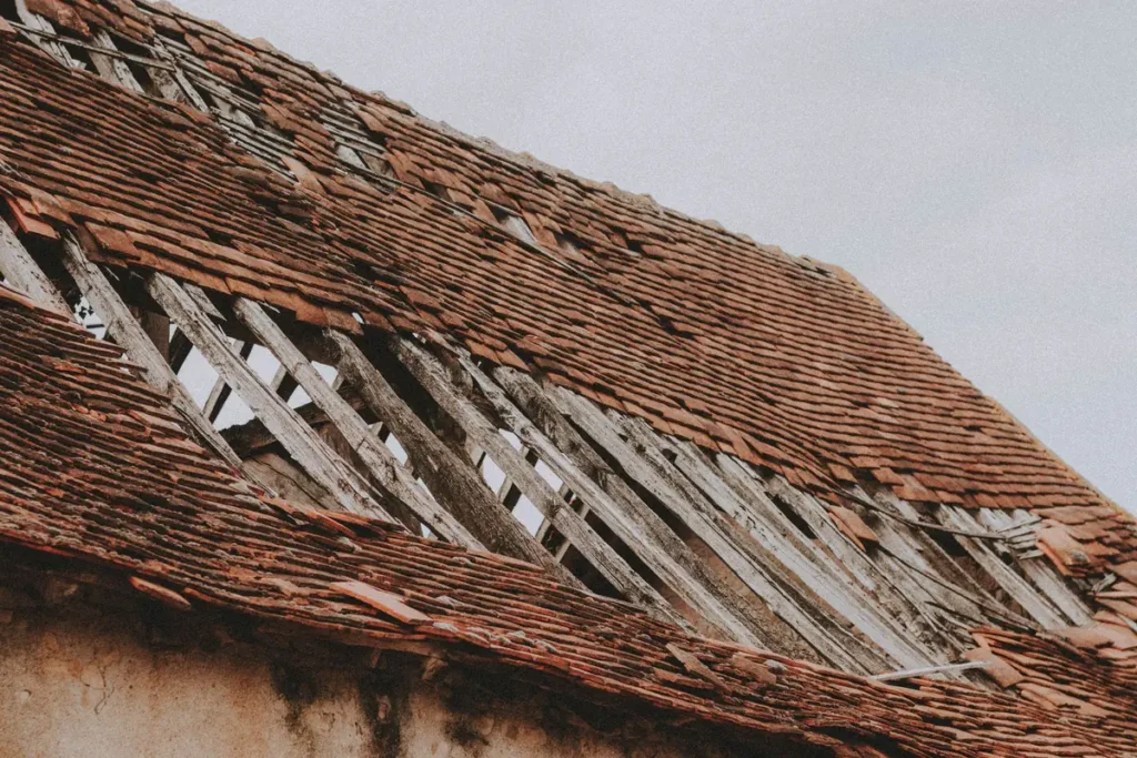 Close-up of a weathered roof with broken and missing shingles