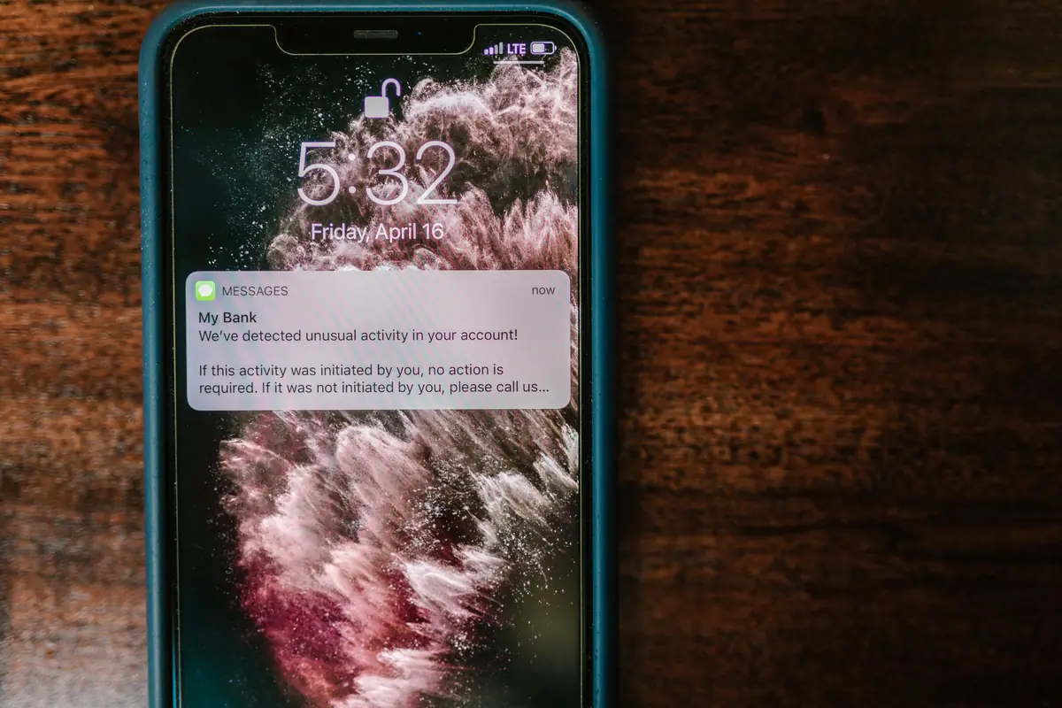 Smartphone on a wooden table showing a new alert notification on the lock screen
