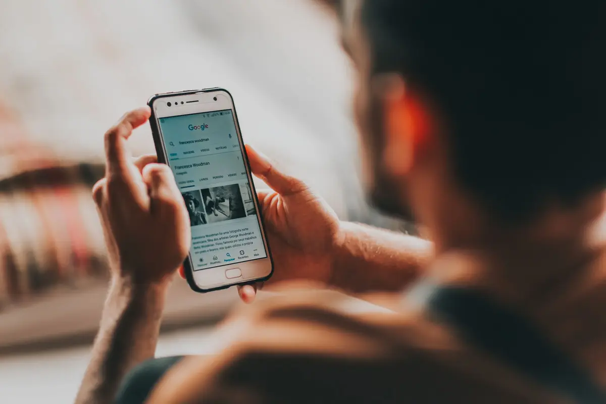 Person scrolling Google results on a smartphone at home