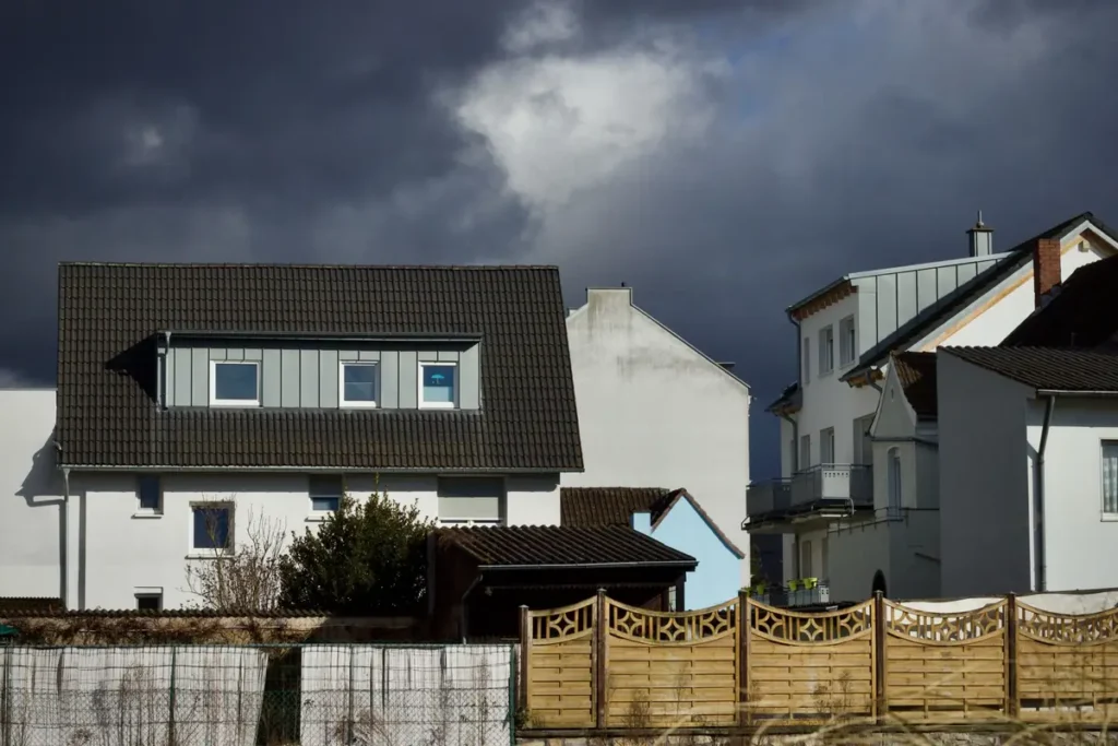 Dark storm clouds gathering over a row of suburban houses