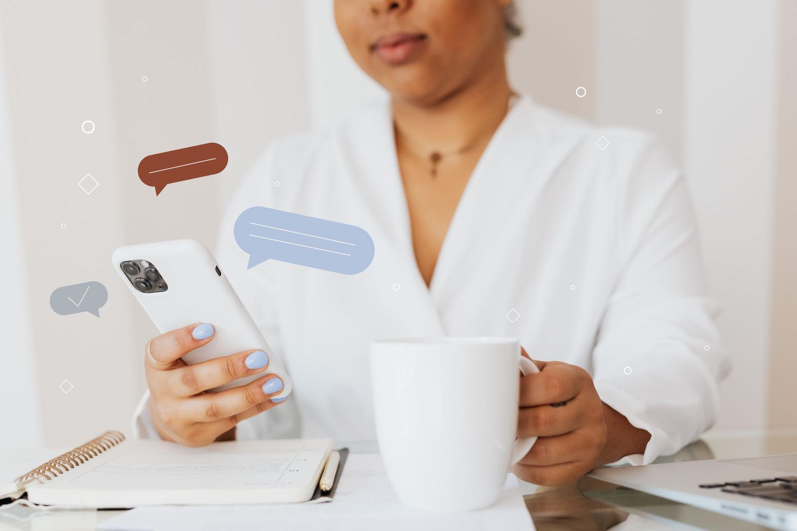 Woman holding a smartphone and a coffee cup as chat message bubbles float beside the screen