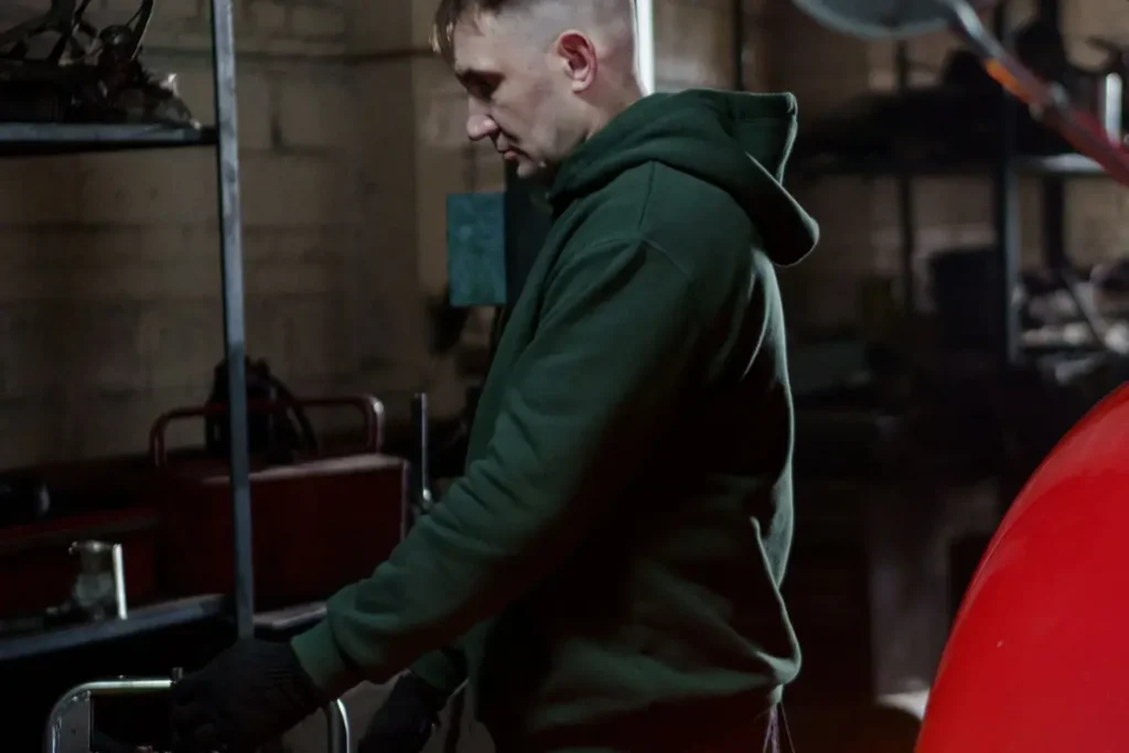 Auto technician working beside a car in a repair shop
